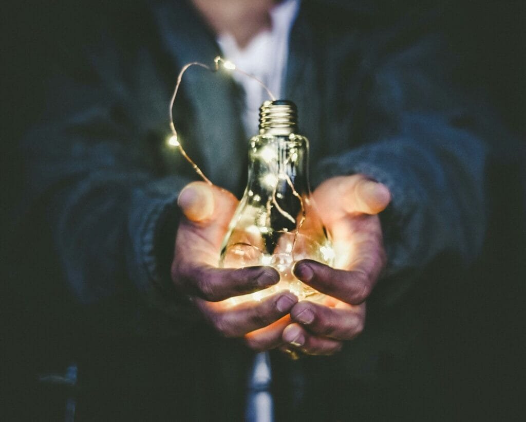 a person holding a light bulb with lights